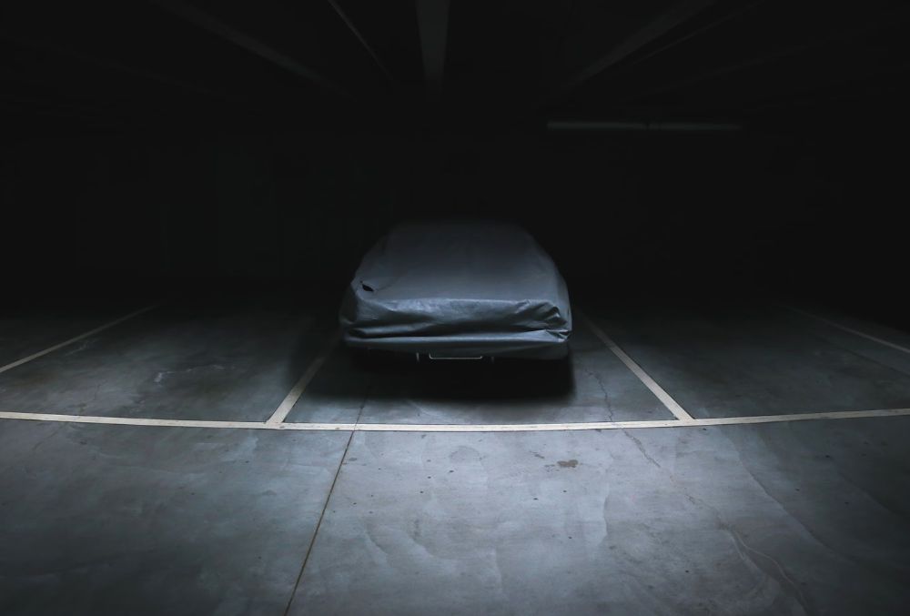 Dark garage room with a parked car